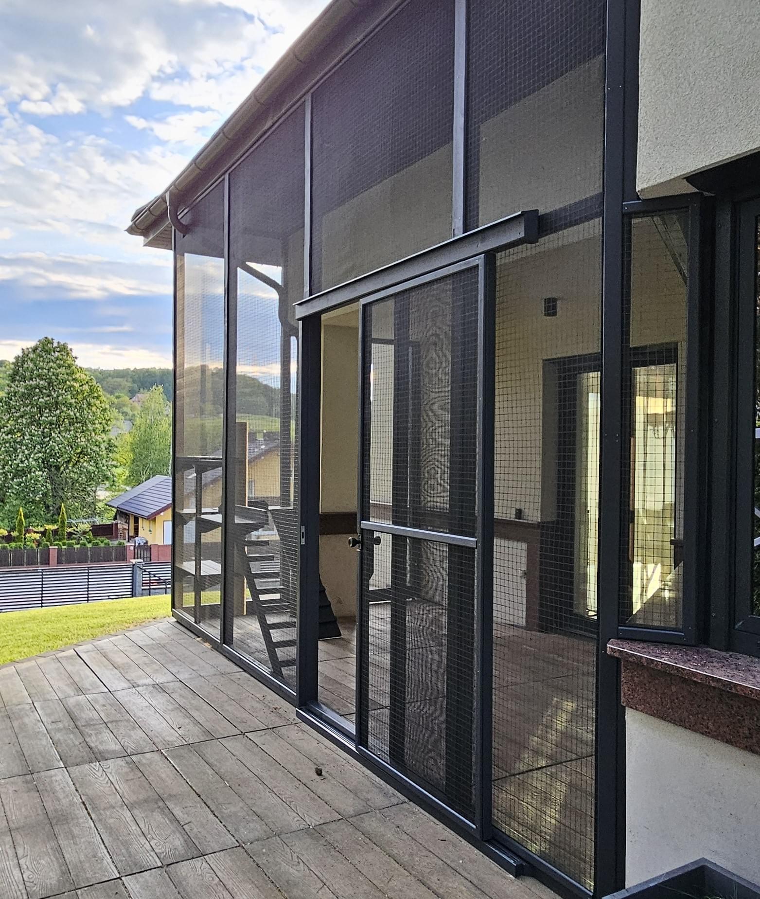 kot siedzący na półce w wnętrzu woliery