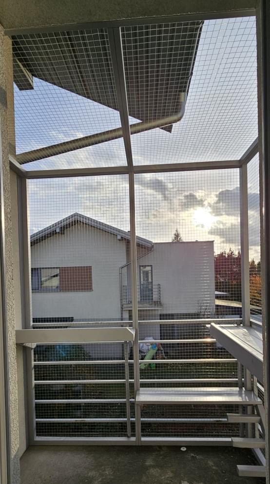 widok na dużą wolierę dolegającą do domu jednorodzinnego